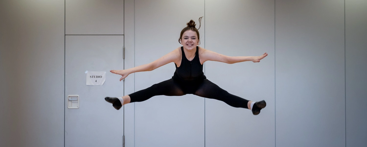 Performing Arts student does the splits in a studio